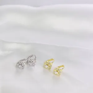 Dettaglio di orecchini a cerchio a zampa di gatto in argento e oro.