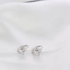 Dettaglio macro di orecchini a cerchio zampa di gatto in argento con zirconi