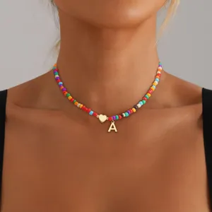 Girocollo con perline colorate e ciondolo con lettera A dorata, gioiello stile bohémien.