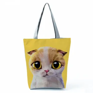 Détail en gros plan d'un sac cabas en toile imprimé chat mignon avec des bretelles grises.