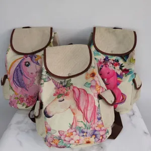 Close-up detail of canvas backpack featuring charming unicorn and floral print pattern.