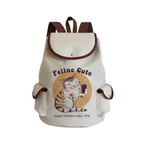 Detailed view of canvas backpack showing cute cat print graphic and brown leather trim.