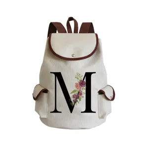 Canvas floral letter M backpack detail view, brown trim design, casual daily use