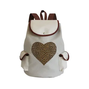 Canvas backpack detail showing leopard heart pattern and brown leather trim for daily use.