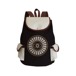 Canvas backpack detail featuring central eye print pattern, adjustable straps and front pockets.