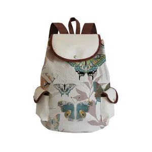 Canvas backpack with butterfly print, brown leather trim, flap closure and double front pockets.