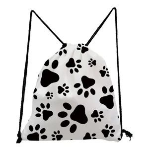 Close-up detail of white drawstring backpack featuring a black paw print pattern and black cords.