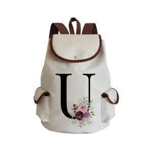 Close-up of the stylish canvas backpack featuring a floral letter U design and brown leather trim.