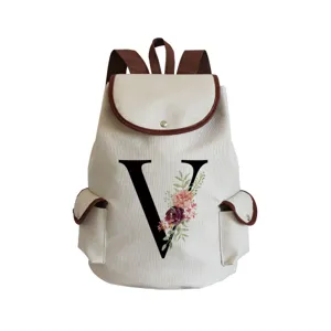 Detailed view of canvas backpack featuring floral letter V print and brown leather trim.