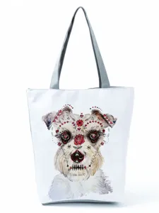 Detailed view of the canvas tote bag featuring a unique dog print and sturdy grey handles.