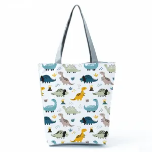 Primo piano della borsa tote in tela con stampa di dinosauro e manici grigi resistenti.