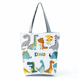 Dettagli della borsa tote in tela con stampa di dinosauri simpatici e motivi di cartoni.