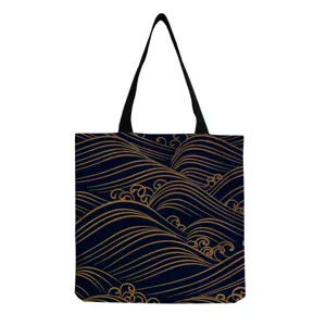 Detail of dark blue canvas tote bag featuring elegant golden wave pattern and black handles.