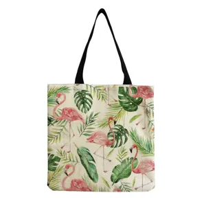Dettaglio borsa shopper in tela con stampa di fenicotteri tropicali e manici resistenti.