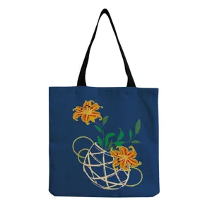 Blue canvas tote bag detail showing the artistic yellow lily and woven basket print clearly.