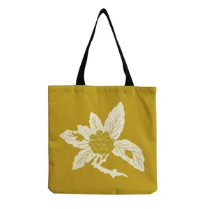 Detail view of the yellow canvas tote bag featuring a white botanical floral print pattern.