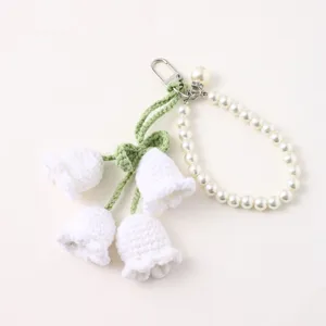 Handmade crochet lily of the valley keychain with elegant pearl strap and metal clasp fashion.