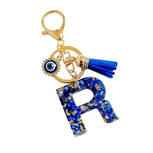 Blauwe letter R sleutelhanger met boze oog hanger en blauw kwastje voor cadeautjes.