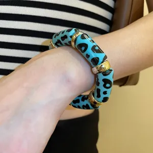 Blue leopard print acrylic bracelet detail view showing gold spacer beads and elastic design.