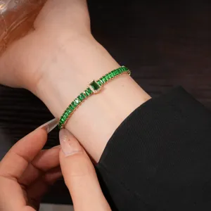 Exquisite green baguette cubic zirconia tennis bracelet detail shot, elegant gold finish.