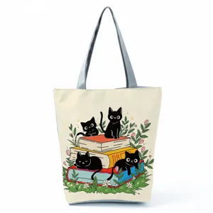 Close-up of cute black cat and books print canvas tote bag, detail of fabric texture and print.