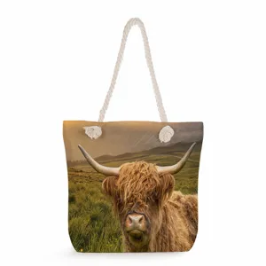 Highland cow print close-up view of the canvas tote bag featuring thick woven rope handles.