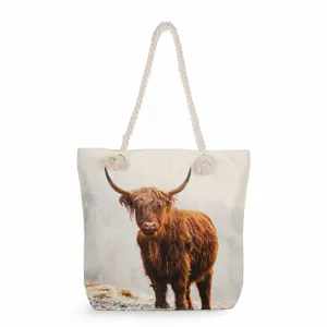 Detailed view of a Scottish Highland cow print canvas tote bag featuring thick rope handles.