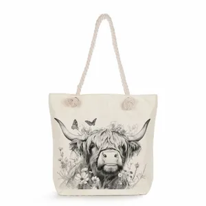 Detailed view of the canvas tote bag featuring a cute highland cow and floral print.
