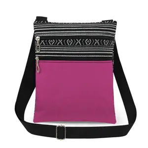 Canvas schoudertas detail met roze voorzak, dubbele rits en zwarte verstelbare band.