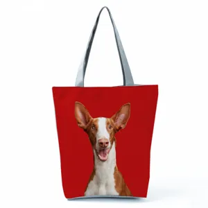 Close-up detail of the canvas tote bag featuring a vibrant red dog print and sturdy grey handles.