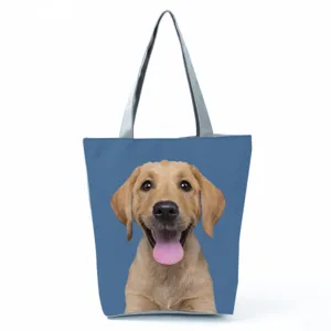Close-up detail of the cute golden puppy print on the blue fabric tote bag surface clearly.