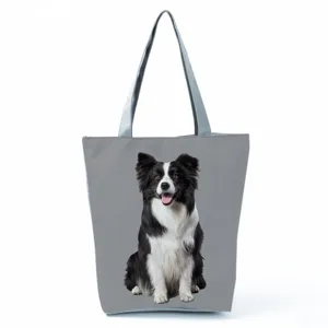 Close-up of the grey canvas tote bag featuring a realistic border collie print and durable handles.