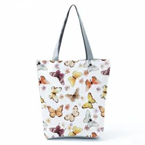 Butterfly print tote bag detail showing watercolor pattern and grey straps texture.