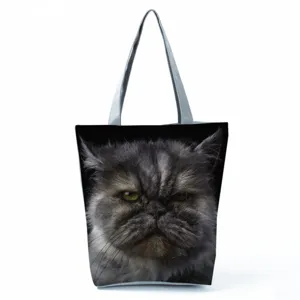 Detailed view of canvas tote bag featuring realistic grumpy cat face print and handles.