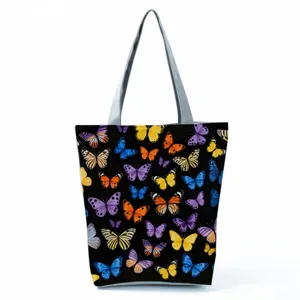 Close-up of the butterfly print tote bag showing vibrant colors and grey shoulder straps.