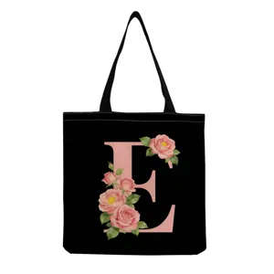 Sac cabas en toile noire avec lettre E rose et motif floral, sac shopping pratique.