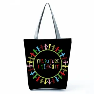 Close-up detail of the black canvas tote bag featuring a colorful teacher themed print design.