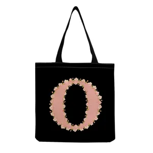 Vue détaillée du sac cabas en toile noire avec un imprimé lettre O florale rose et anses.