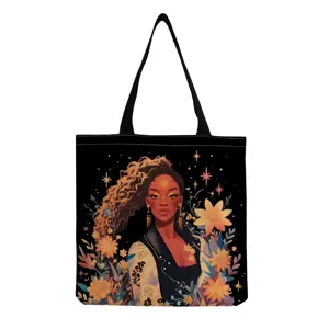 Détail de sac cabas en toile noire avec impression de femme artistique et fleurs.
