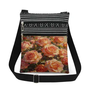 Details view of the vintage rose print canvas crossbody bag with double zippers and black strap.