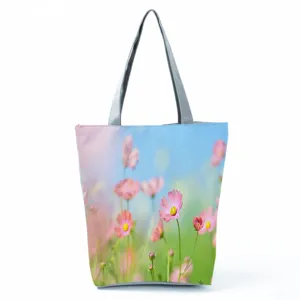 Vue détaillée du sac cabas à fleurs, motif cosmos rose et poignées grises résistantes.