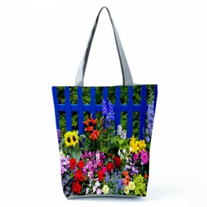 Détail de cabas à imprimé floral montrant un motif de jardin vibrant et des anses grises.