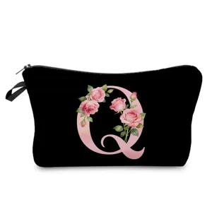 Primer plano de bolsa cosmética negra con diseño de letra floral rosa y cierre de cremallera.