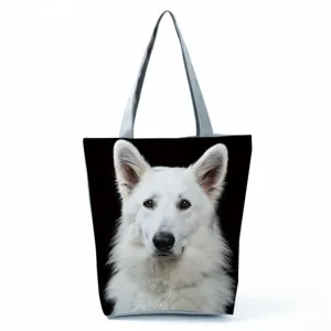 Close-up of black canvas tote bag featuring realistic white dog print and double handles.