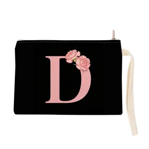 Black canvas cosmetic pouch detail showing pink floral letter D print and white wrist strap.