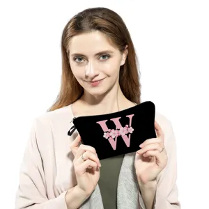 Bolsa de maquillaje negra con letra rosa W y estampado de flores de cerezo con cremallera.