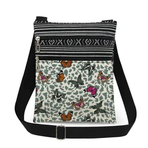 Primer plano del bolso cruzado con doble cremallera, estampado de mariposas y rayas.