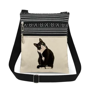 Detailed view of the black and white cat print crossbody bag, showcasing zipper and strap.