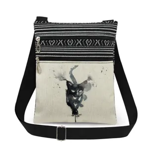 Canvas crossbody bag detail showing black cat ink print, dual zippers and adjustable strap.