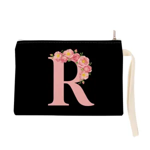 Black canvas cosmetic bag with pink floral letter R print, portable makeup pouch with strap.